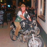 Seth Pitt astride a cow-hide clad motorbike outside the Cat & Wheel in Bristol